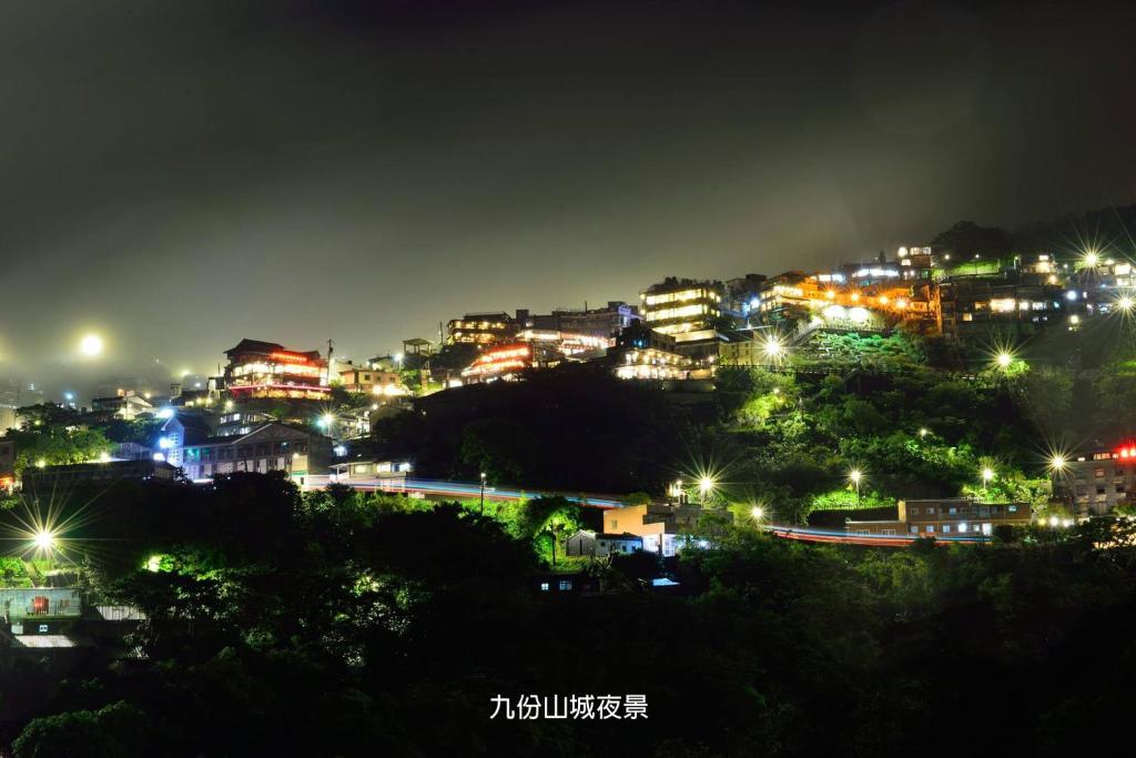 a city lit up at night with lights at Blue Sky B&amp;B in Jiufen
