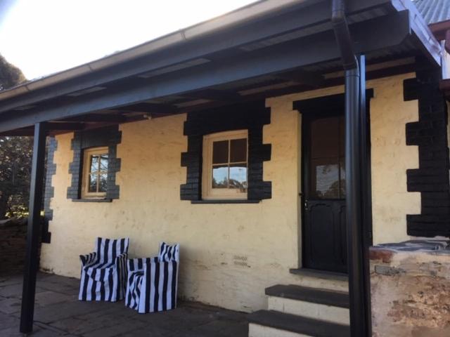 a house with three blue and white pillows on it at Peppertree Cottage in a beautiful Rural Setting in Mintaro
