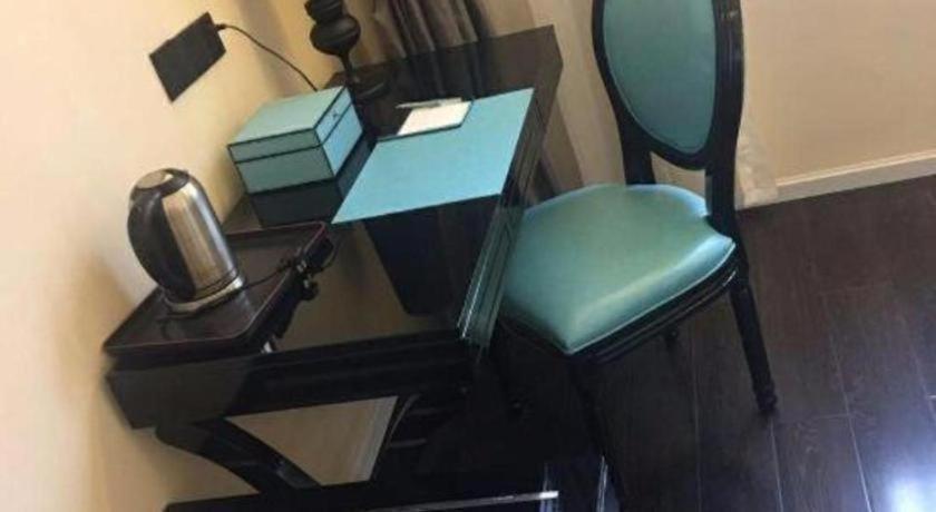 a desk with a chair and a telephone on it at Xana Lite Leshan Haochi Street Branch in Leshan