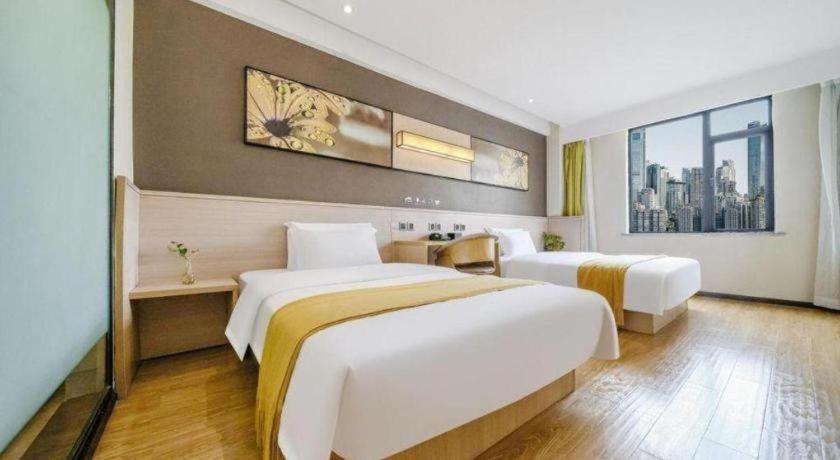 una camera d'albergo con due letti e una grande finestra di IU Hotel Chengdu Jianyang Xiongzhou Plaza a Jianyang