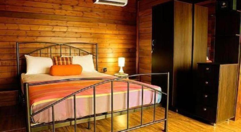 a bedroom with a bed and a wooden wall at Ma-Oya Retreat in Andiramada