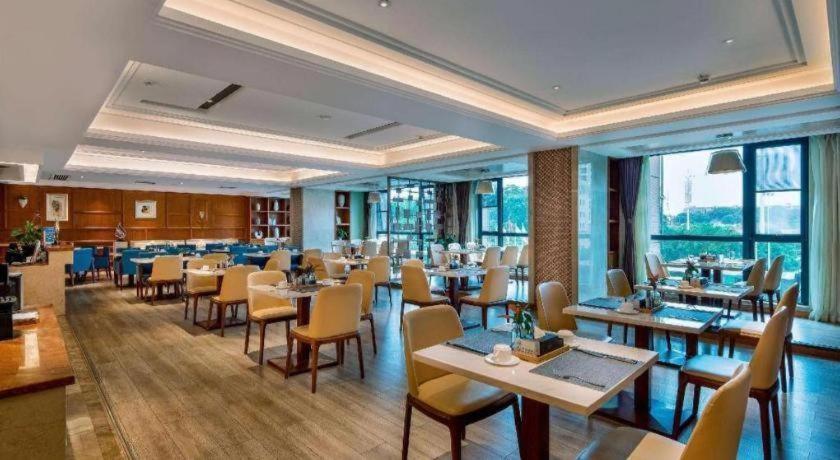 um restaurante com mesas, cadeiras e janelas em Days Hotel by Wyndham Hunan Changsha Convoy em Changsha
