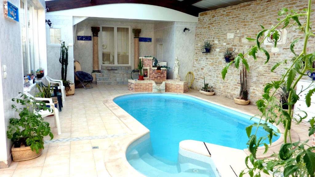 a swimming pool in a house with plants at Le relais de la cure in Saint-Juire-Champgillon