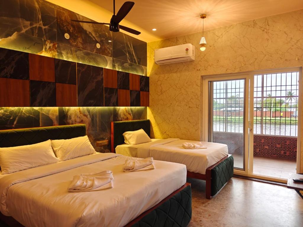 ein Hotelzimmer mit zwei Betten und einem Fenster in der Unterkunft Estuary Dreamz BOATEL in Virāmpattinam