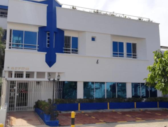 a large white building with a blue cross on it at Hotel Coosonav Cartagena in Cartagena de Indias