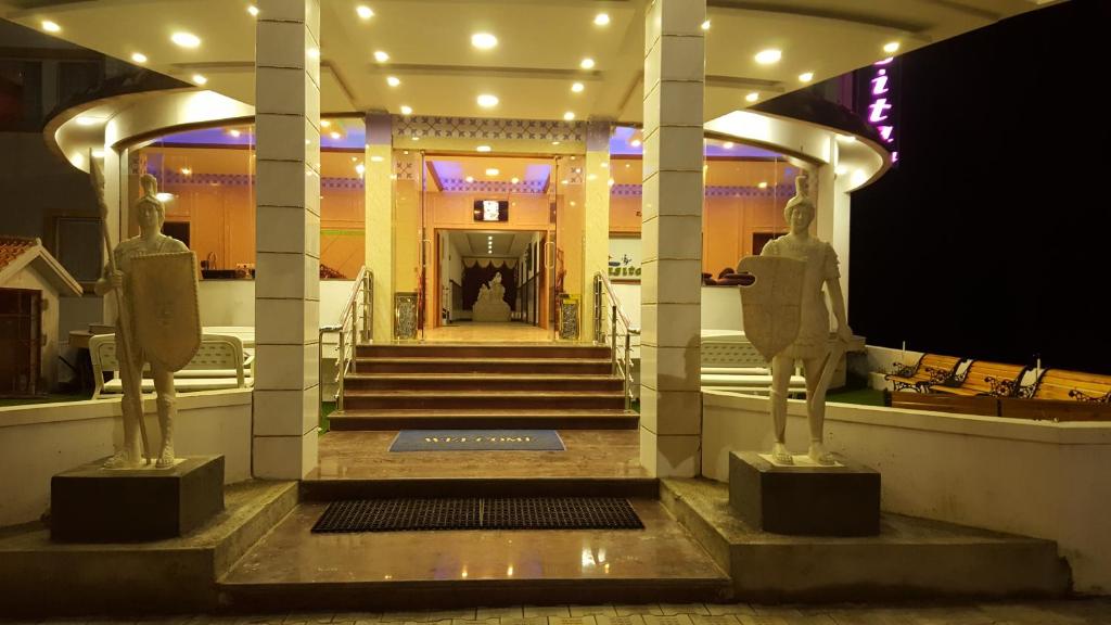 two statues of men in front of a building at TNV Casita Inn in Yercaud