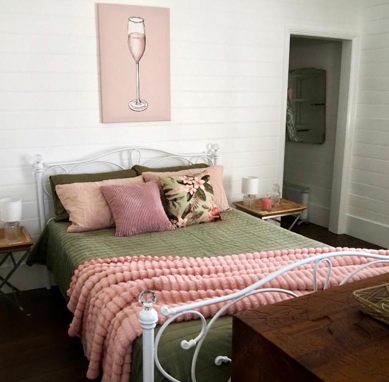 a bed with a green comforter and a wine glass at Smithtown Champagne Bed and Bubbles in Smithtown
