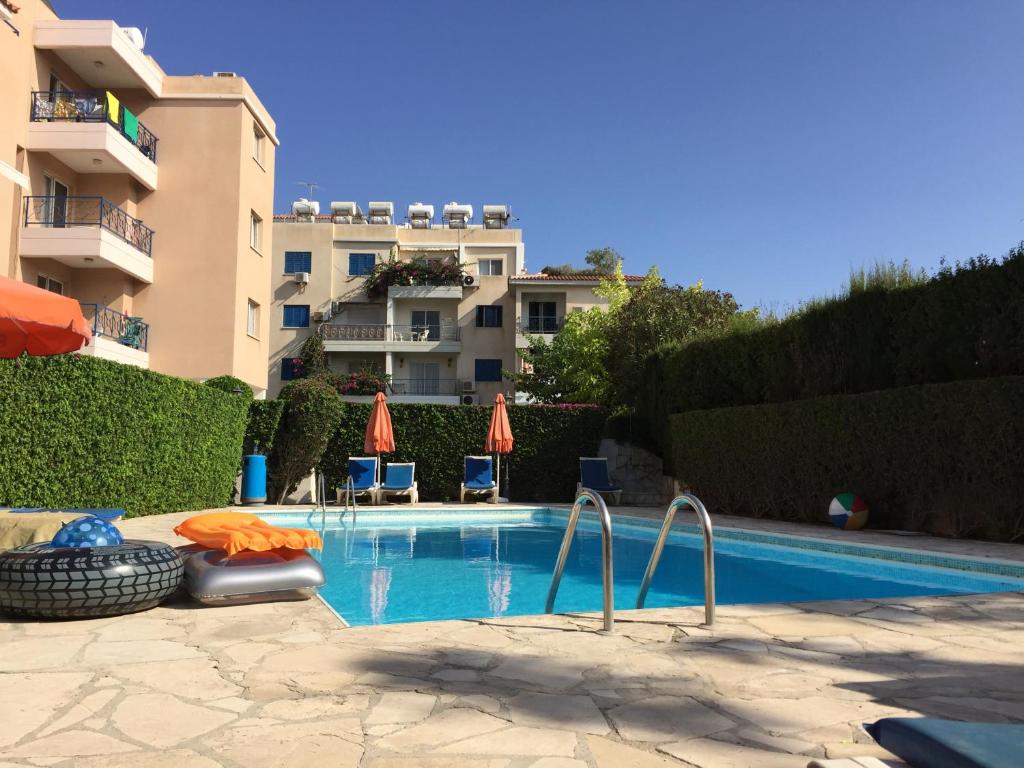 a swimming pool in front of a building at The Paphos Pafia 2 Apartment in Paphos