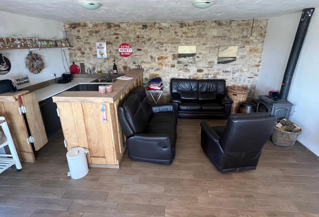 a living room with leather chairs and a stove at Vakantiewoning Verdre met geweldig uitzicht in Saint-Vith