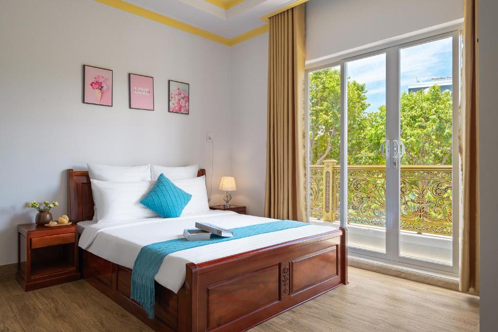 sypialnia z łóżkiem i dużym oknem w obiekcie Song Ngọc Hotel Phan Thiết w mieście Phan Thiet
