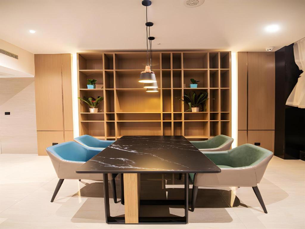 una sala da pranzo con tavolo e sedie neri di City Comfort Inn Changsha Sifangping University of National Defense Science and Technology a Changsha