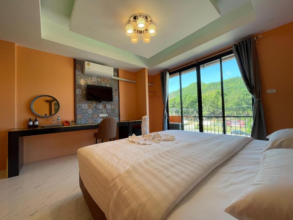 Un dormitorio con una cama grande con una ventana grande. en The Morocco, en Kaeng Kachan