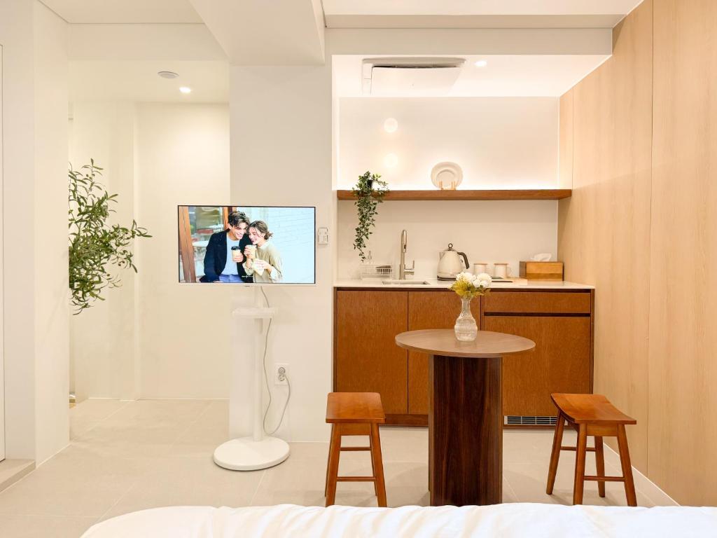 a living room with a table and a picture on the wall at 이루다스테이 호텔 고척돔점 in Seoul