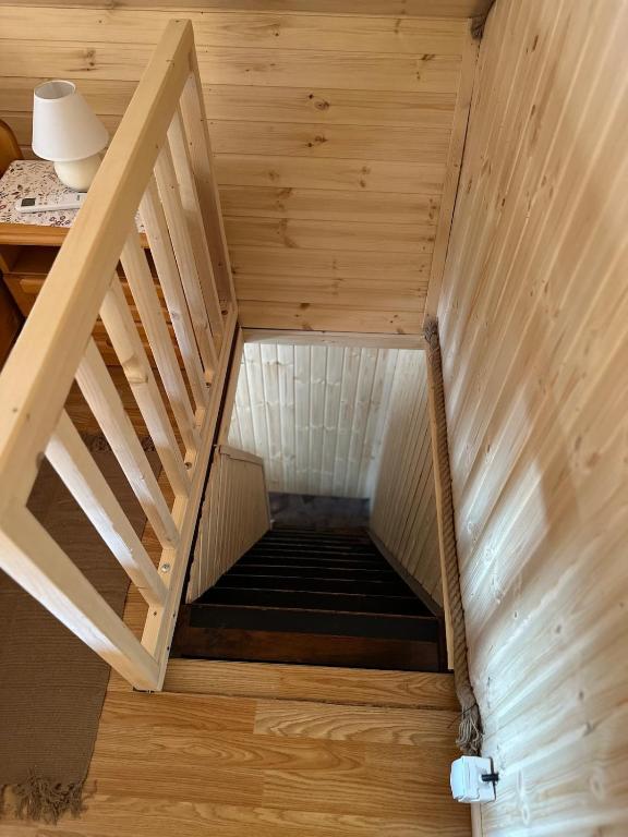 an attic room with a staircase in a wooden house at Chata v údolí in Rozbehy