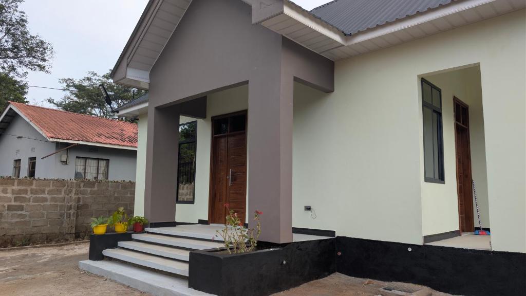 una casa bianca con portico e scale di Dans place a Moshi