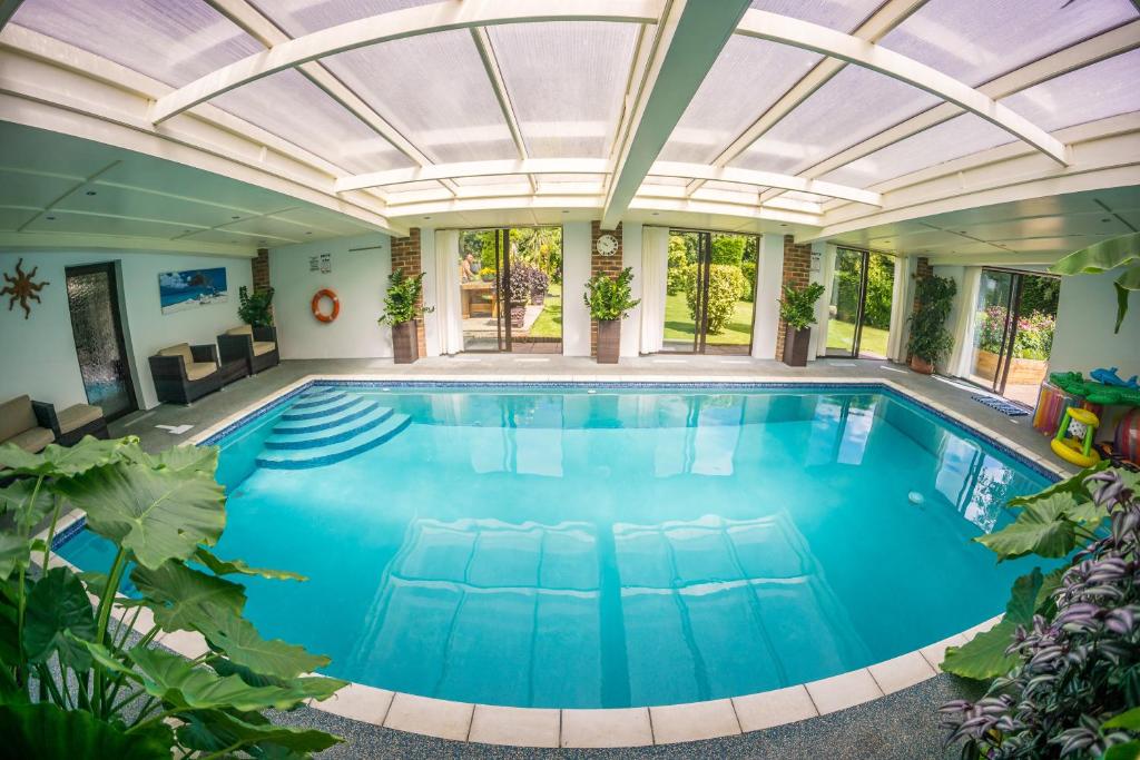 una piscina coperta con soffitto in vetro di Badgers Den - Covehurst Bay Holiday Cottage a Hastings