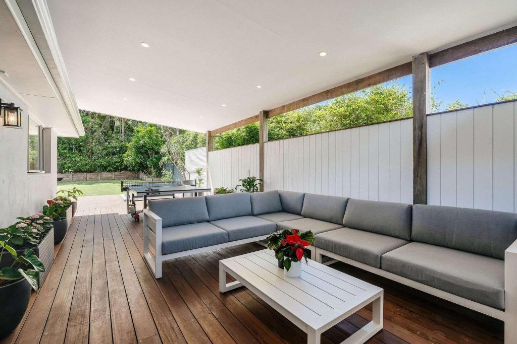 a living room with a couch and a table at Forresters Lodge by Coast Hosting in Wamberal North