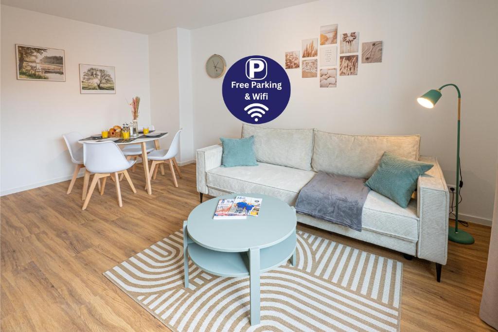 ein Wohnzimmer mit Sofa und Tisch in der Unterkunft Sailor's Cabin - Neues Apartment in Deichnähe mit Garage von STAY YOUR WAY in Bremerhaven