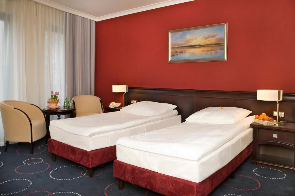 two beds in a hotel room with red walls at Hotel Admirał in Gdańsk