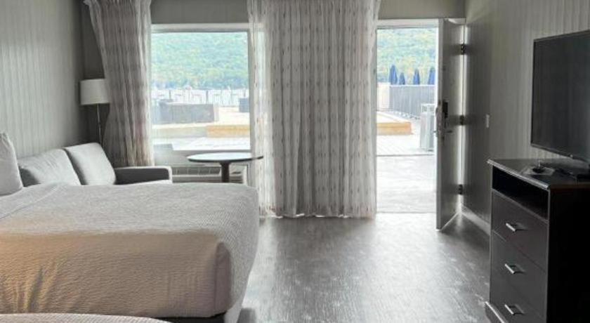 a hotel room with a bed and a large window at The Georgian Resort in Lake George
