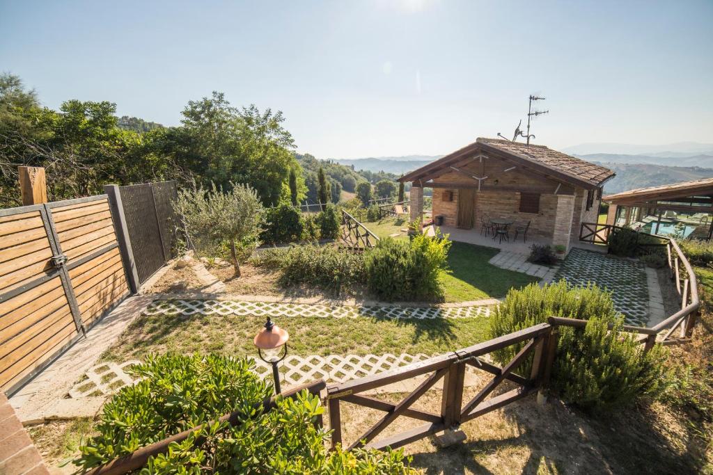 un giardino con recinzione in legno e una casa di Country House Ca' Brunello a Urbino