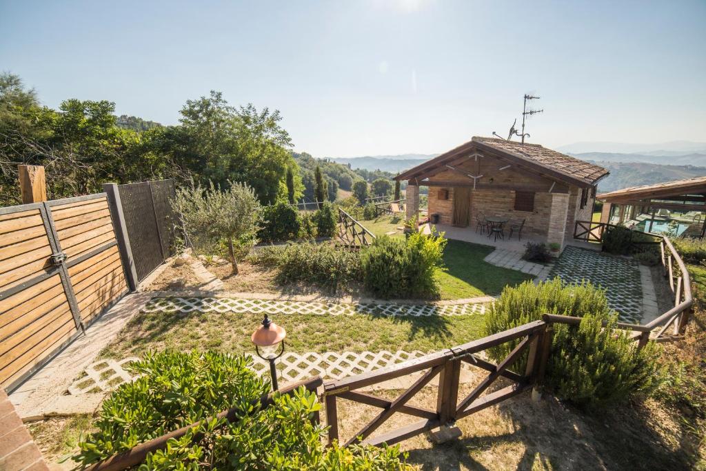 a garden with a wooden fence and a house at Country House Ca' Brunello in Urbino