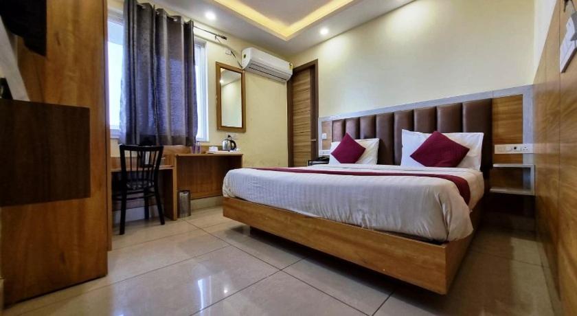 a bedroom with a bed and a desk in a room at MLS Prime Inn - Near Dehradun Railway Station in Dehradun