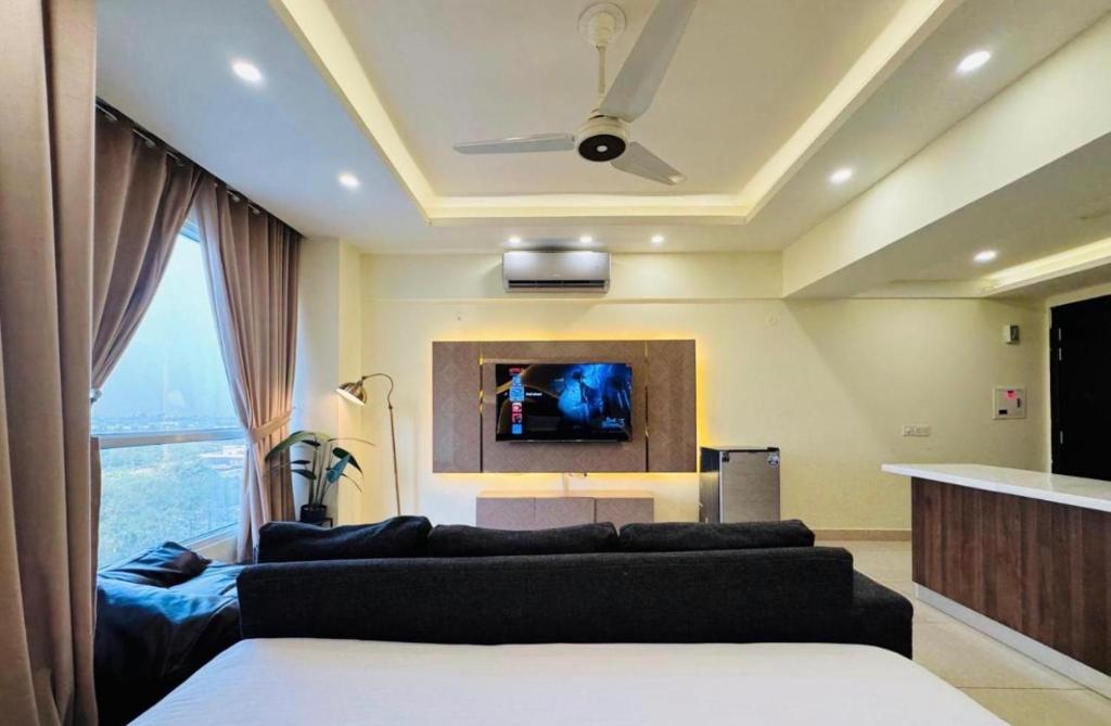 a living room with a couch and a tv at Montressa Executive Stay - Gold Crest Mall Phase 4 Lahore in Lahore
