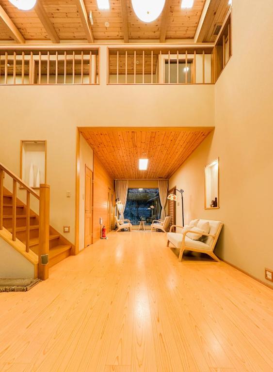 a large living room with wooden floors and a staircase at Hanastay Kawachinagano in Nagano