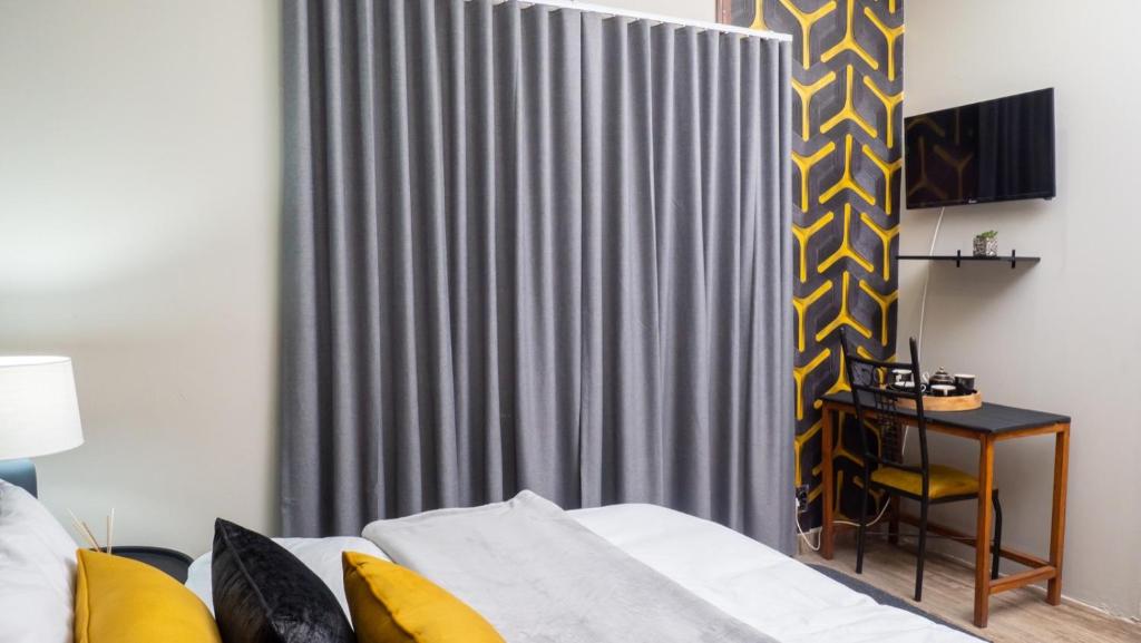ein Schlafzimmer mit einem Bett und einem grauen Vorhang in der Unterkunft EGB Guest House in Springs