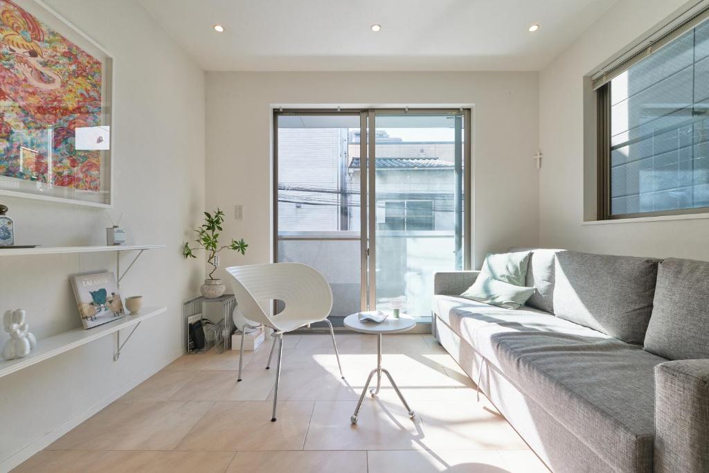 a living room with a couch and a chair at Mint House Ebisu - 3 Story, Artsy & Modern Home in Shibuya in Tokyo