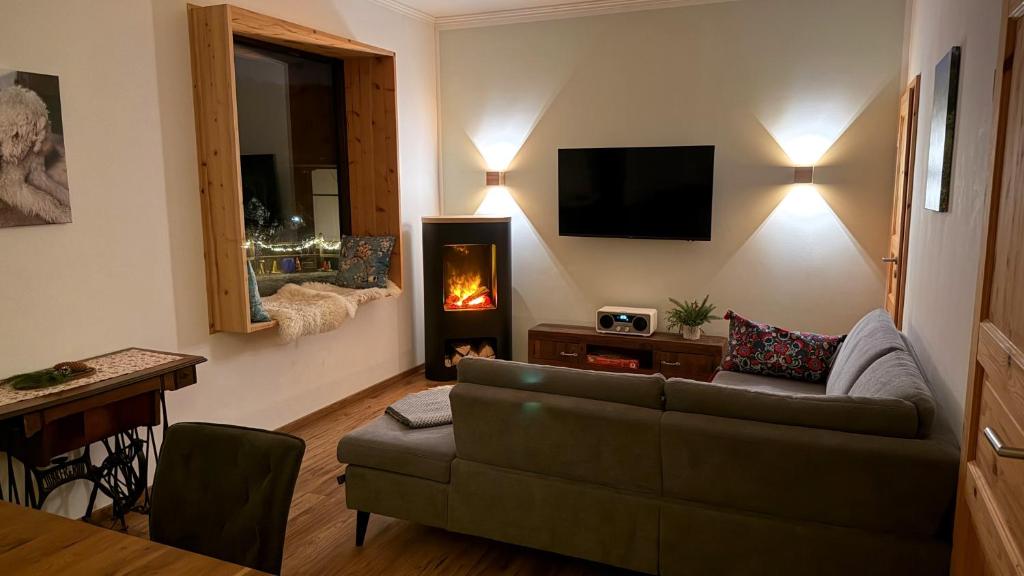 un soggiorno con divano e camino di Landgut Pfauenhof - Landleben genießen auf dem Bio-Reiterhof in der Vulkaneifel a Utzerath