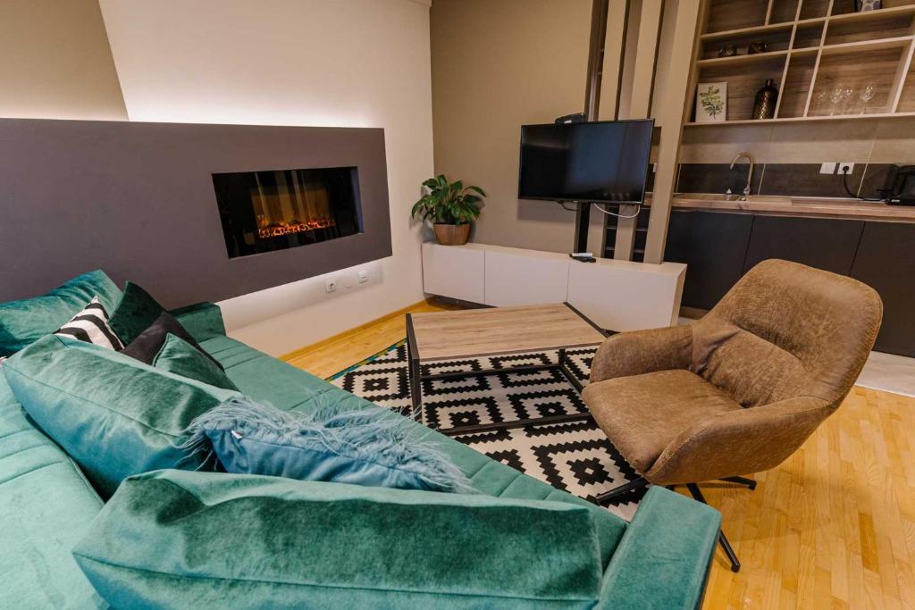 NAR Royalton Deluxe Apartment #74 في نيشْ: غرفة معيشة مع أريكة وكراسي وتلفزيون