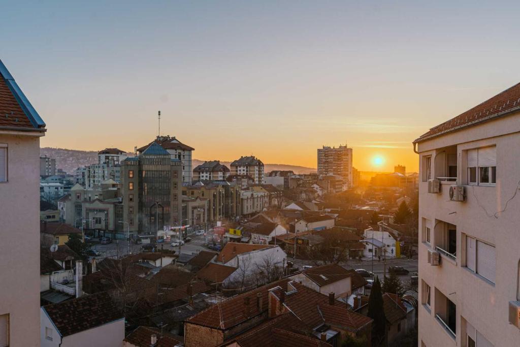 a view of a city with the sun setting at NAR Royalton Deluxe Apartment #74 in Niš