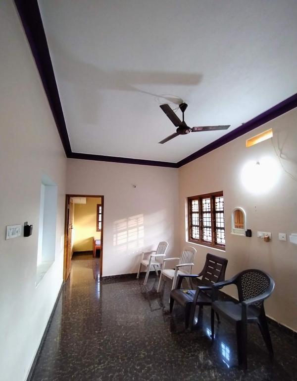 a room with chairs and a table and a ceiling at Homestay Nandana Full apartment with Kitchenware in Gokarna