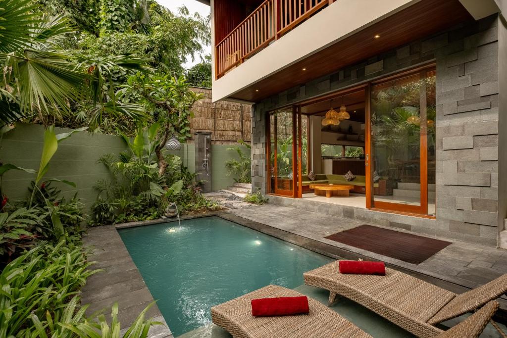 een zwembad in de achtertuin van een huis bij Nauma Ubud Villa in Ubud