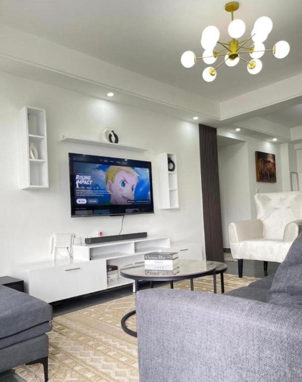 a living room with a flat screen tv on a wall at 2 bedrooms apartment in Riverside drive in Nairobi