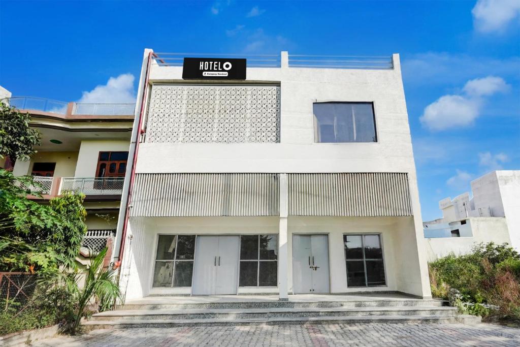 a white building with a sign on it at Hotel O Meerut Central College Formerly Saffron in Meerut