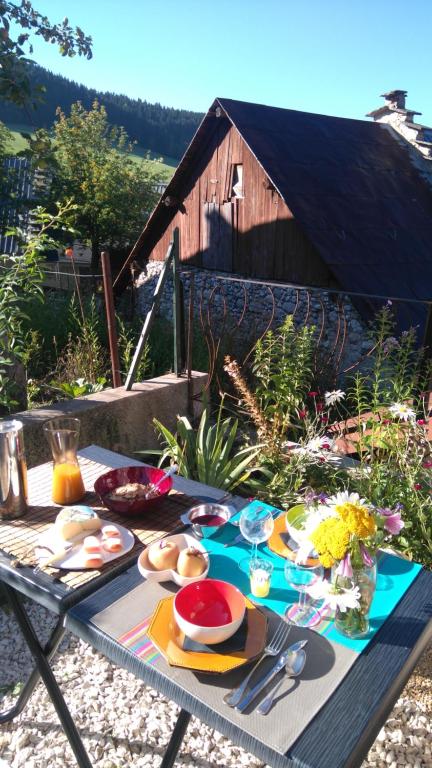 a picnic table with food on it with a barn at Le Petit Chalande in Autrans