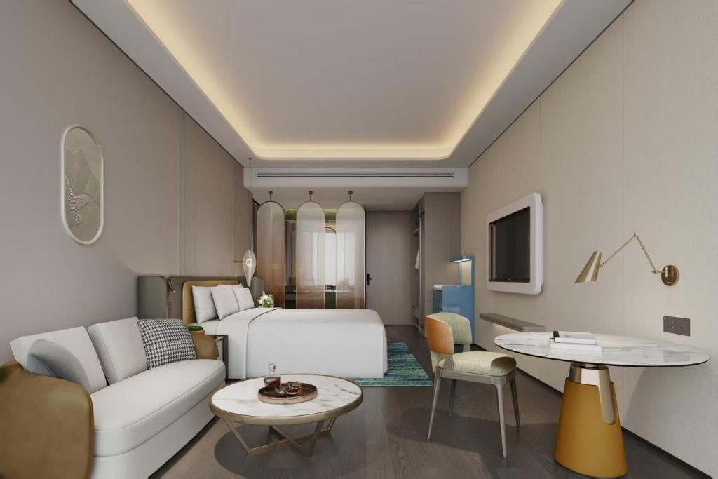 ein Schlafzimmer mit Bett und ein Wohnzimmer in der Unterkunft Days Hotel by Wyndham Leshan Downtown in Leshan