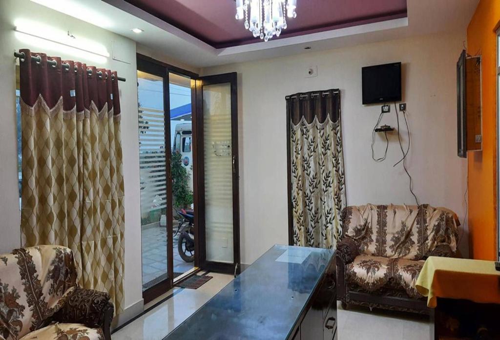 Una sala de estar con dos sillas y una mesa. en POP 84142J Krishnapatnam Grand Inn, en Muttukūru