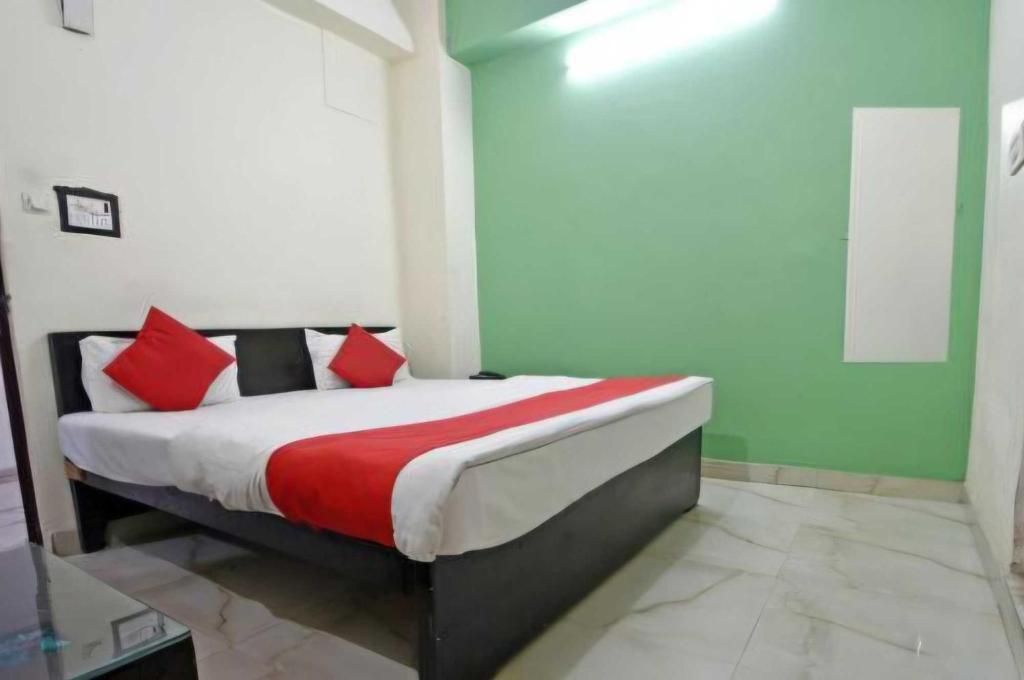 a bedroom with a bed with red pillows on it at Hotel O Rajiv Gandhi Bus Stop Bangalore Formerly Maharaja in Jālahalli