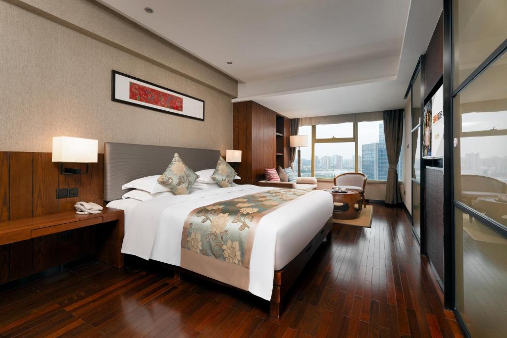 Una habitación de hotel con una cama grande y un escritorio. en SSAW Boutique Hotel Hangzhou Wildwind, en Hangzhou