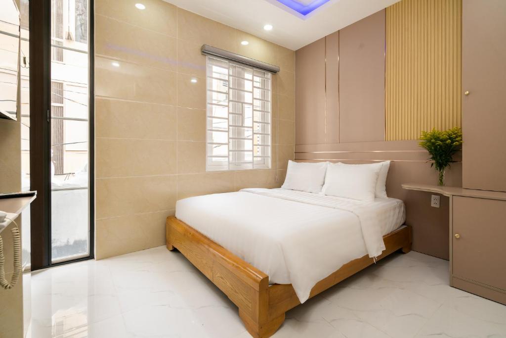 Lucky Star Hotel - Lê Thị Riêng في مدينة هوشي منه: غرفة نوم بها سرير بملاءات بيضاء ونافذة