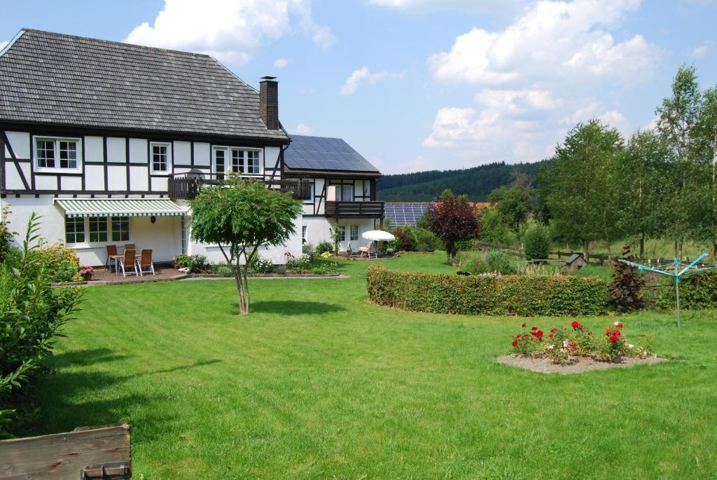 una casa con un patio con flores rojas en Hof Hesse, en Attendorn