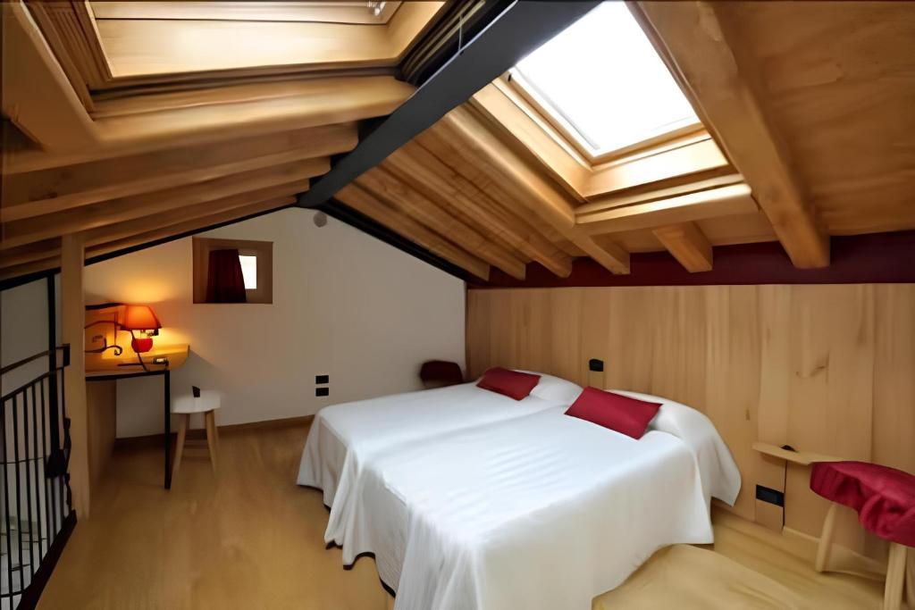 een slaapkamer met een wit bed en een dakraam bij Gustet 5 - Prosecco Hills Holidays in Miane