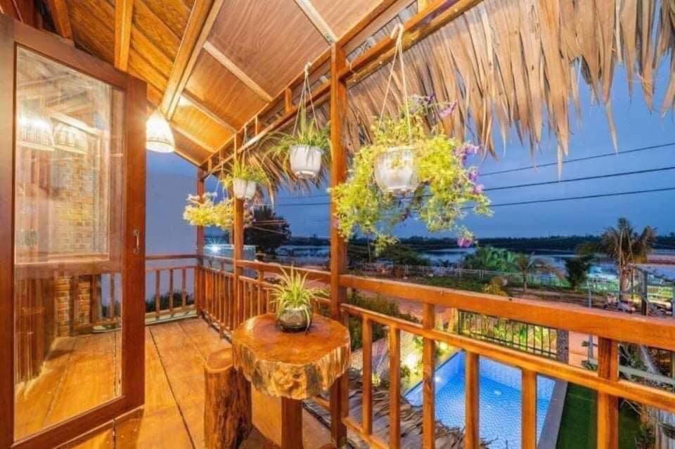 a balcony with a table and a view of the water at Family Tan Thanh in Tân Thành (1)