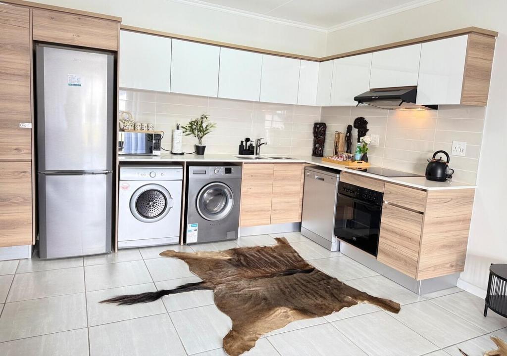 een keuken met een wasmachine en droger op de vloer bij Zuri Marula Luxe in Midrand