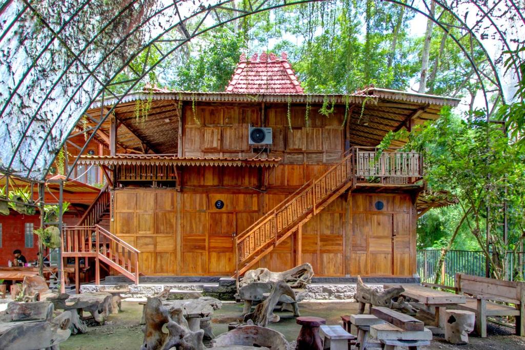 um grande edifício de madeira com varanda e escadas em OYO 95018 Anggrek Homestay Jogja Syariah em Timuran
