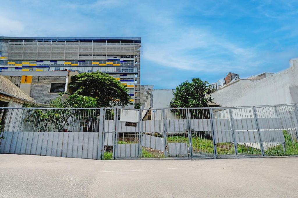 una cerca blanca frente a un edificio en OYO 95041 Griya Indah Homestay, en Djetak
